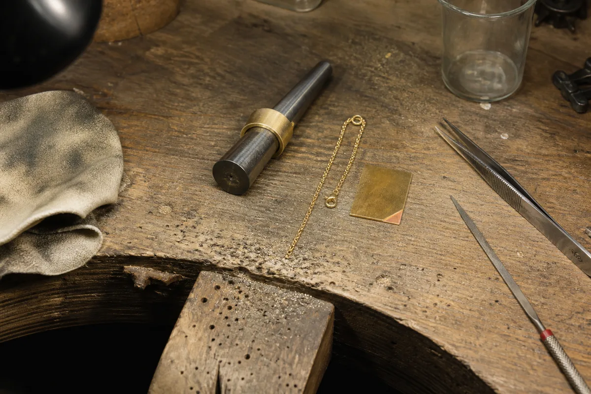 Bijoux en plaqué or posés sur un établi de joaillier